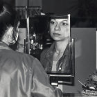 Traditional Asian woman in ornate garment with classic updo reflected in mirror