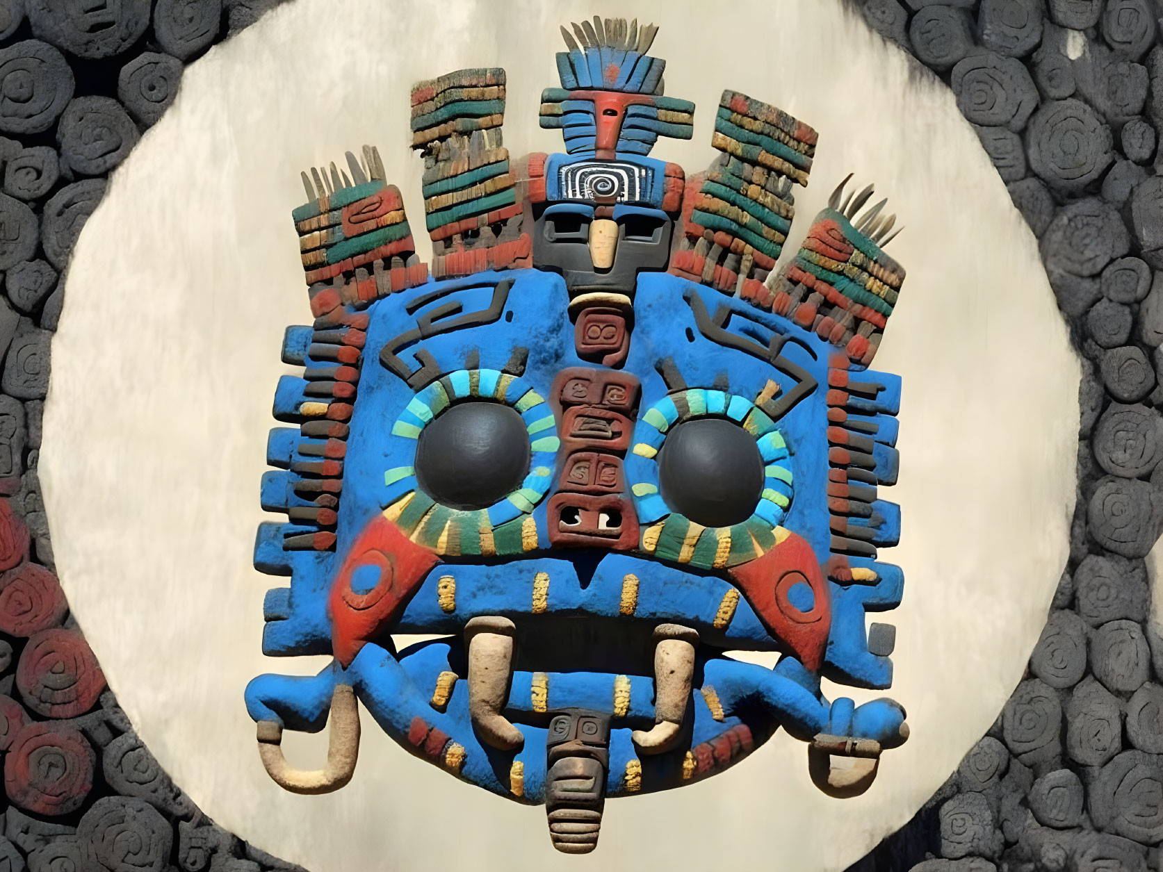 Vibrant Aztec sun stone sculpture with intricate designs in blue, red, and yellow.