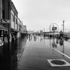 Monochrome image of people with umbrellas on foggy street