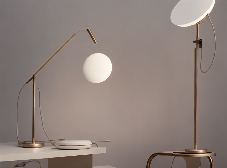 Modern desk lamps with spherical shades on table against gray background