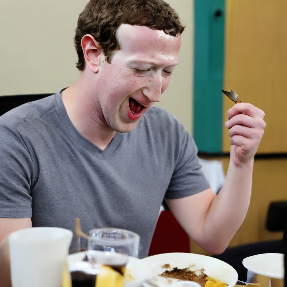 Person in Grey T-Shirt Laughing with Spoon and Plates of Food