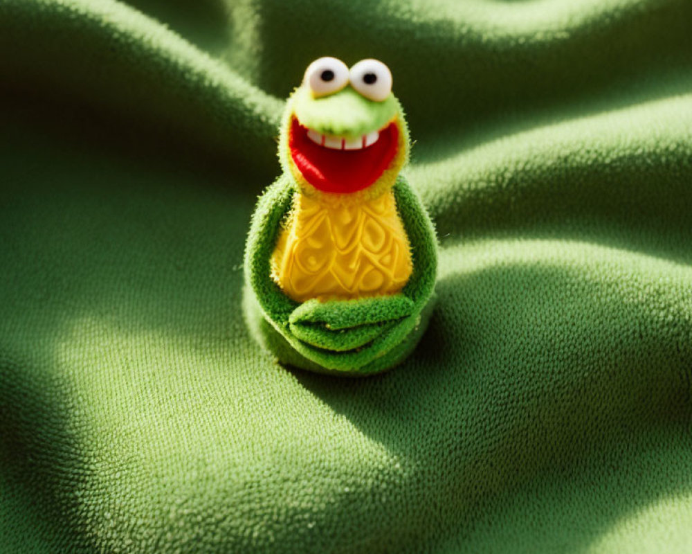 Kermit the Frog Toy on Green Textured Fabric Mimicking Lily Pad Environment