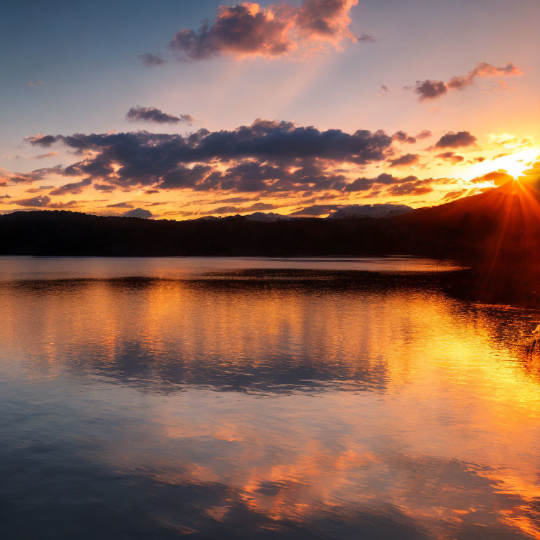 Tranquil Lake Sunset with Sky Reflections and Mountain Silhouette