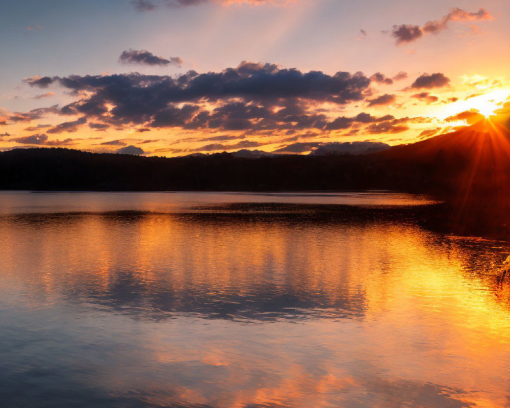 Tranquil Lake Sunset with Sky Reflections and Mountain Silhouette