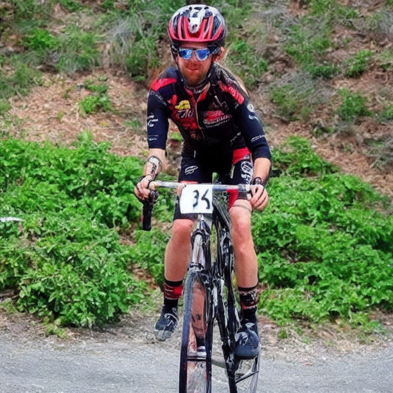 Cyclist in Black and Red Kit with Number 35 Riding Uphill