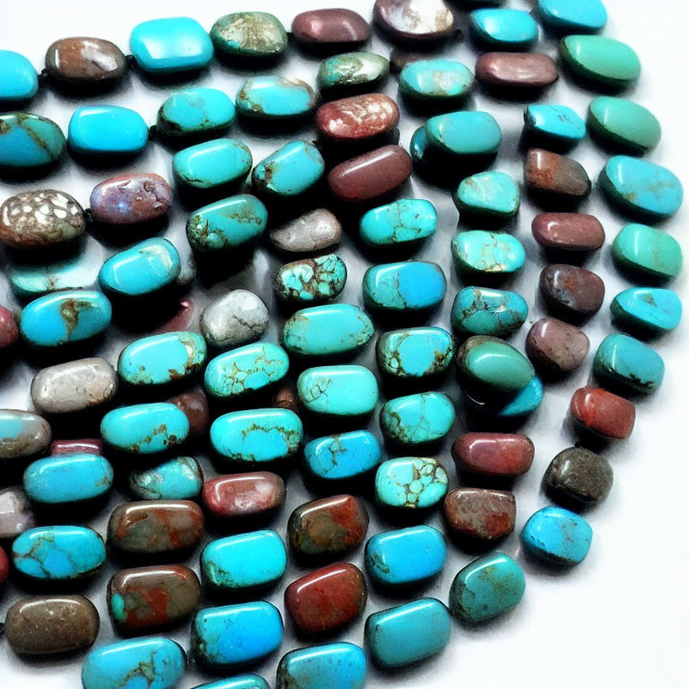 Assorted Turquoise Stones in Blue and Green Shades on White Surface