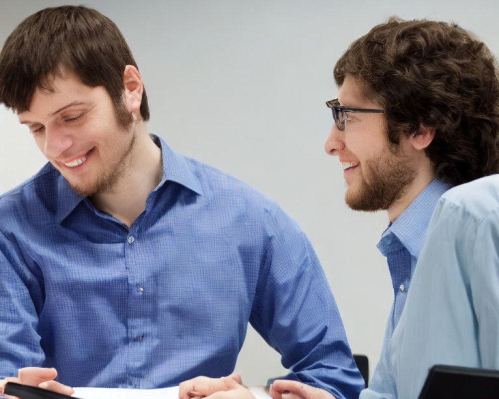 Two Men in Blue Shirts Having a Friendly Conversation