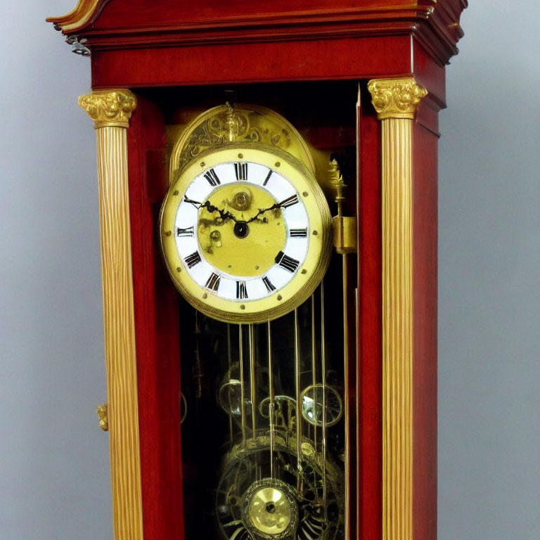 Vintage Grandfather Clock with Gold-Faced Dial and Visible Pendulum in Red Wooden Cabinet