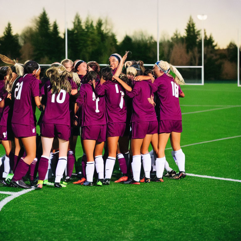 Women's Soccer Team Celebrates in Maroon Jerseys at Dusk