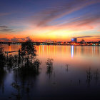 Tranquil river sunset with silhouetted boats and warm reflections