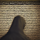 Person in headscarf admiring Arabic calligraphy on wall