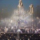 Ornate architecture and water jets illuminated at dusk