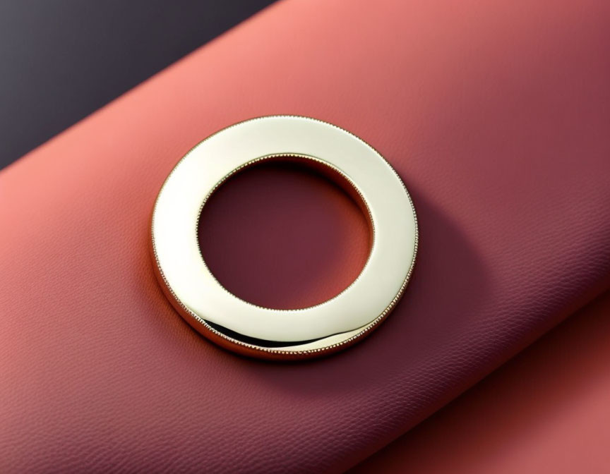 Circular Gold Bracelet on Burgundy Leather Surface