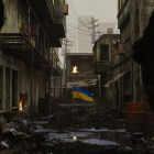 Dystopian alley with glowing green figures and decrepit buildings