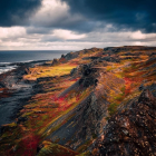 Sunset ocean scene with tumultuous waves and stormy sky in vibrant colors.