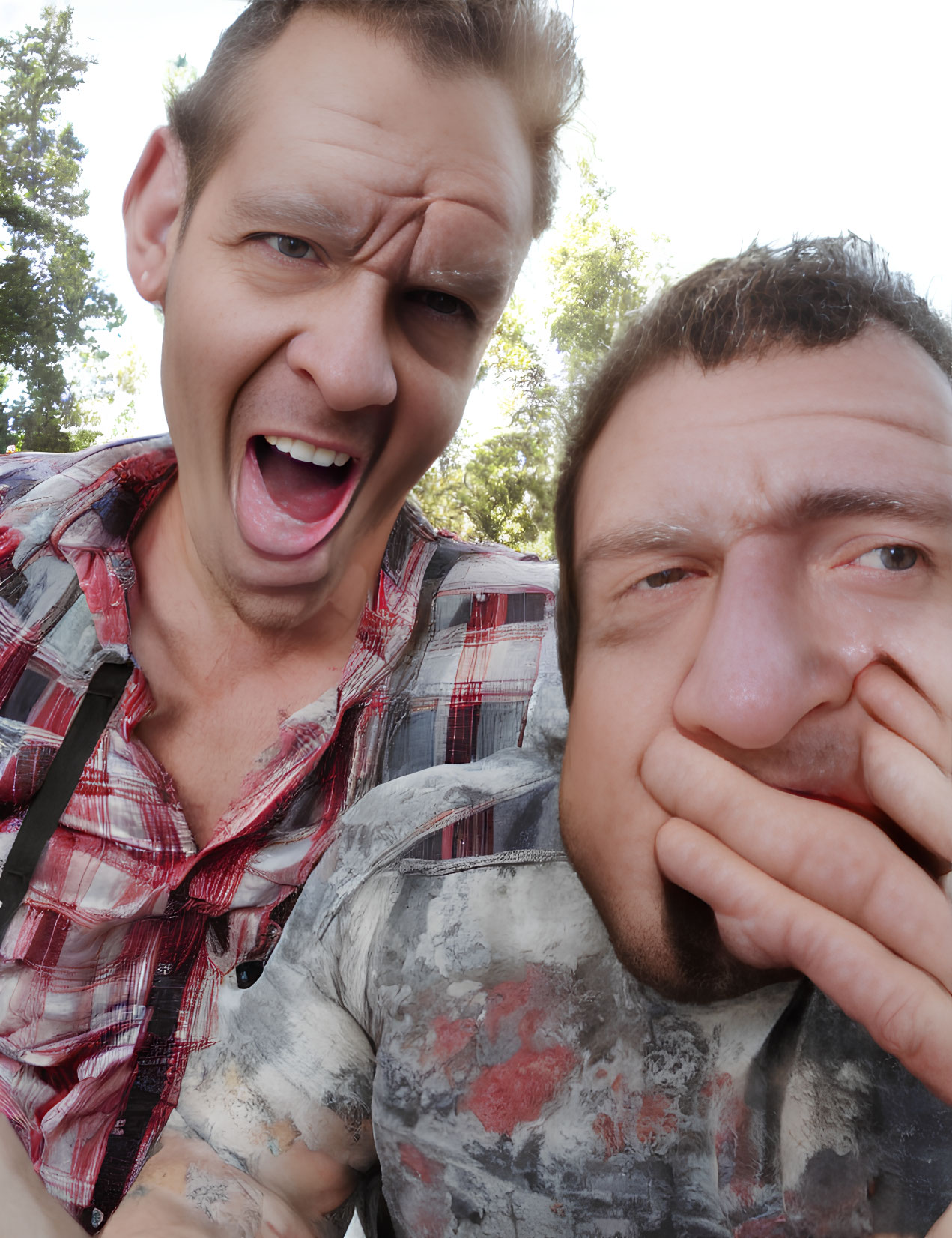 Two men posing with facial expressions outdoors