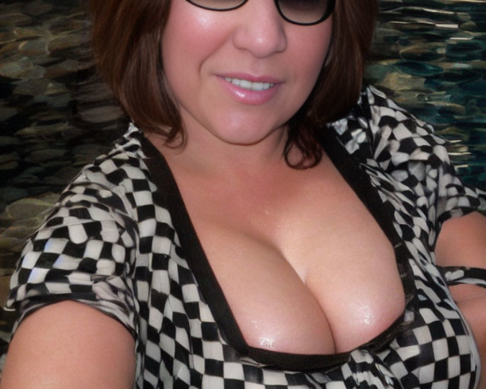 Woman in black and white checkered swimsuit smiling in pool