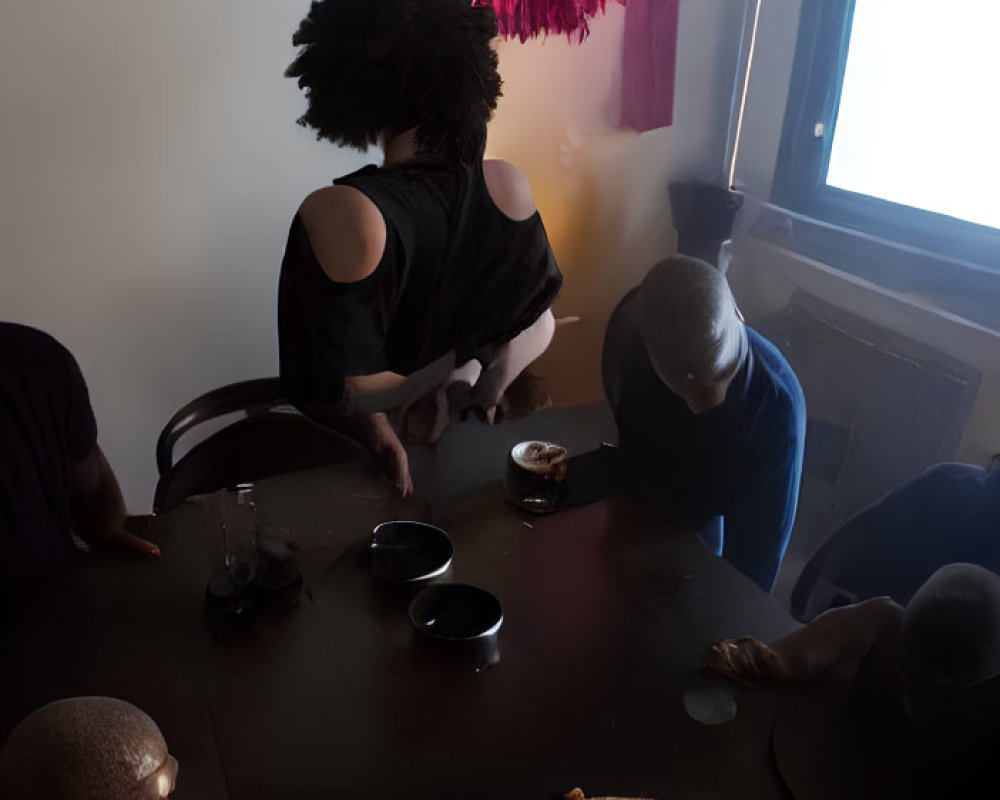 Four People Around Table with Pizza and Wall Artwork