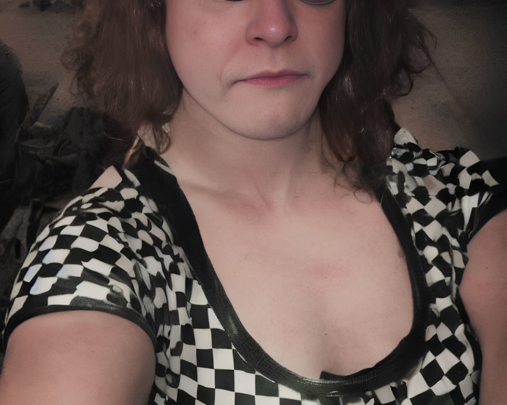 Checkerboard-patterned top selfie in dimly lit background