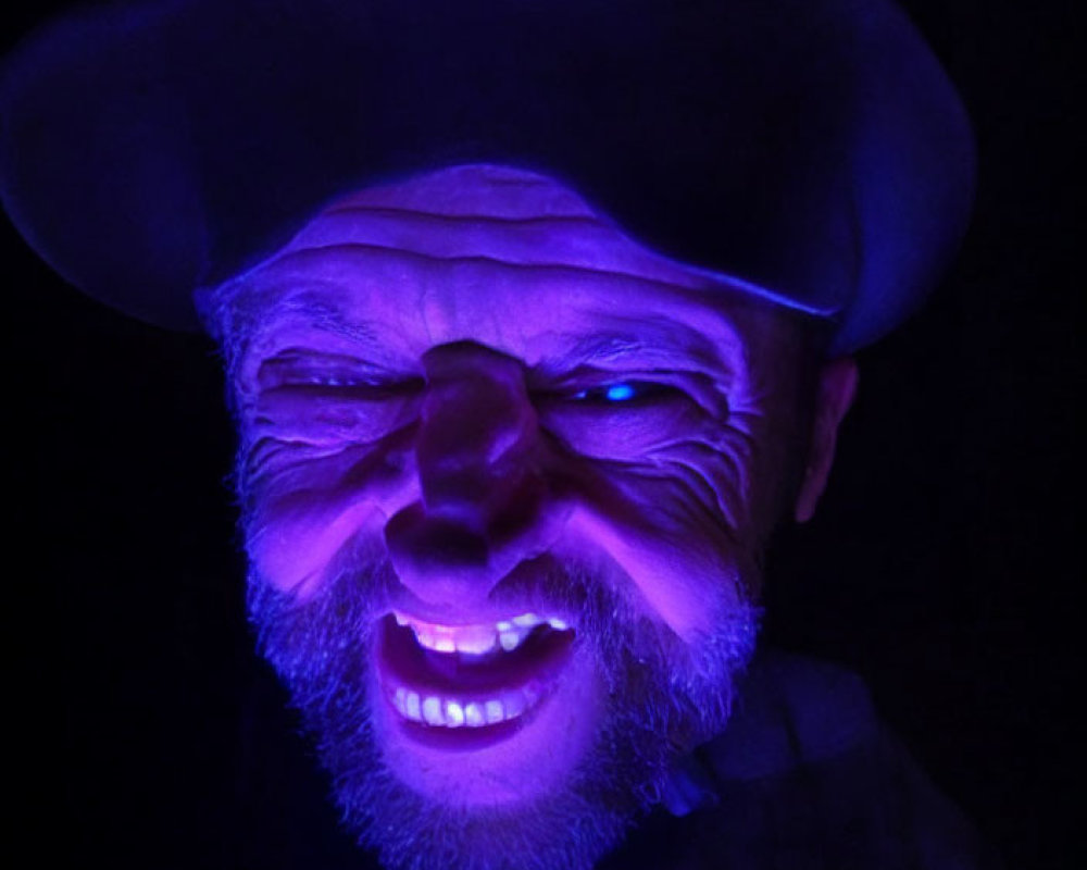 Smiling person with hat under blue light, mysterious face focus