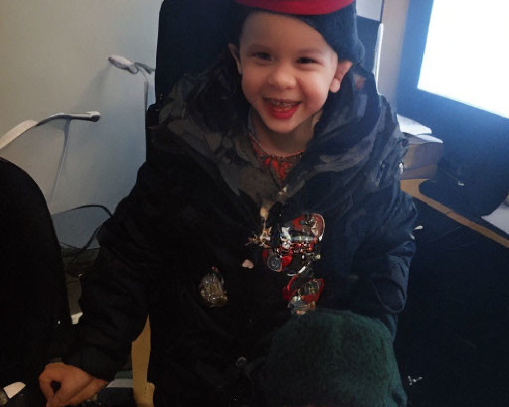 Smiling children in colorful hats and jackets indoors