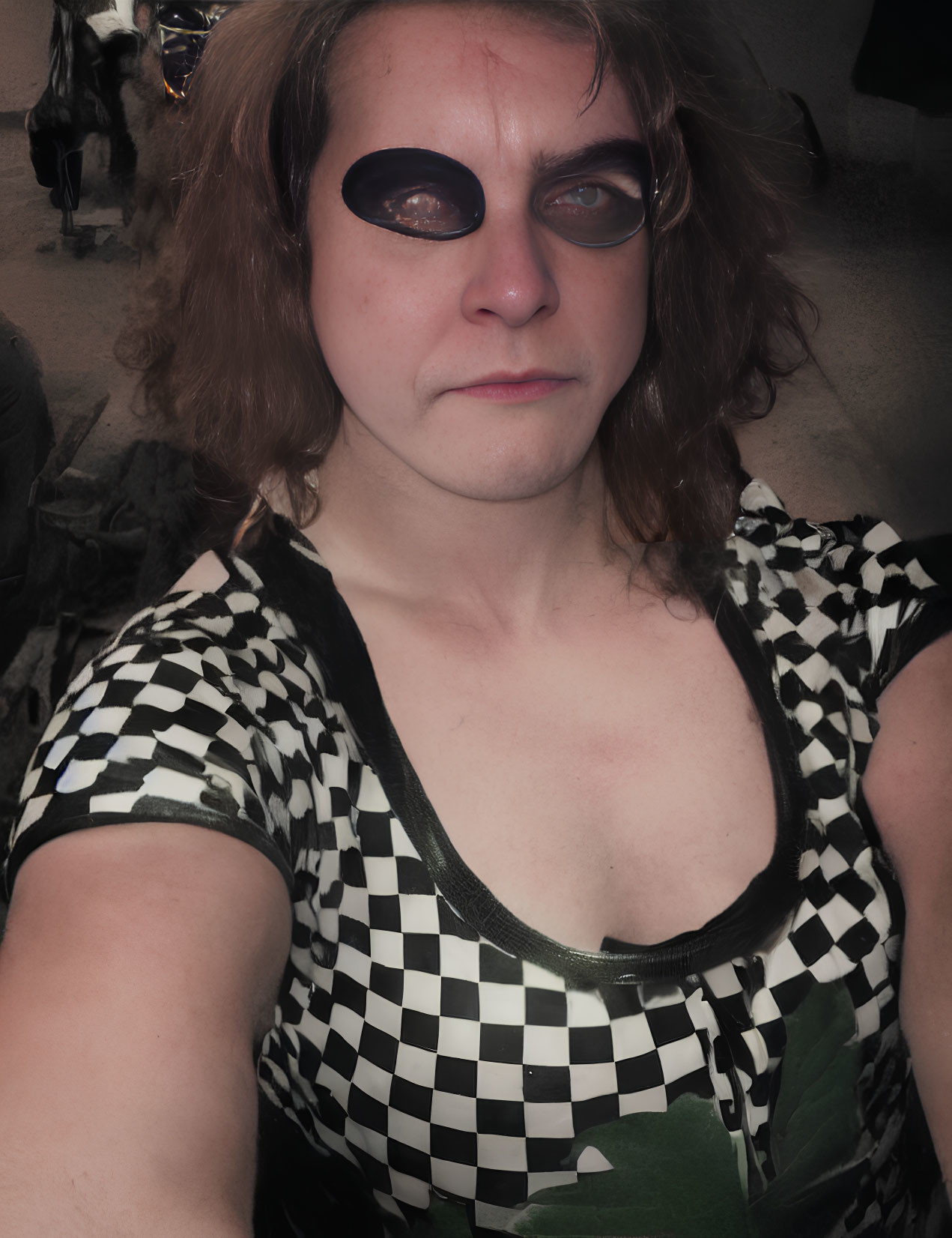 Checkerboard-patterned top selfie in dimly lit background