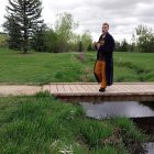 Cello player on grass field with colorful paint streaks