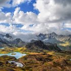 Vibrant surreal landscape: colorful hills, rock formations, dynamic clouds