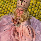 Regal woman with golden hair in pink gown and jeweled hat on golden background