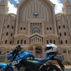 Blue Motorcycle Parked in Front of Ornate Gothic Church with Falling Autumn Leaves