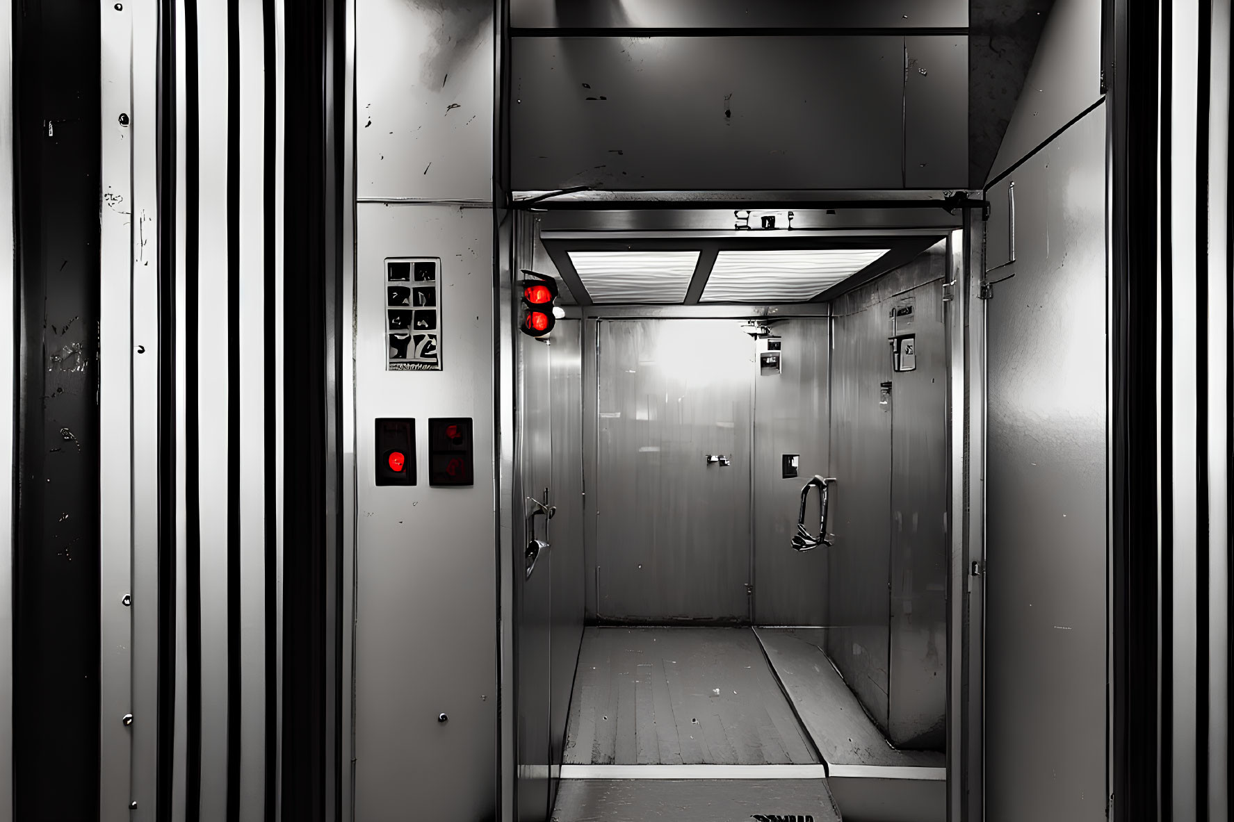 Monochrome industrial elevator interior with metal walls and control panel