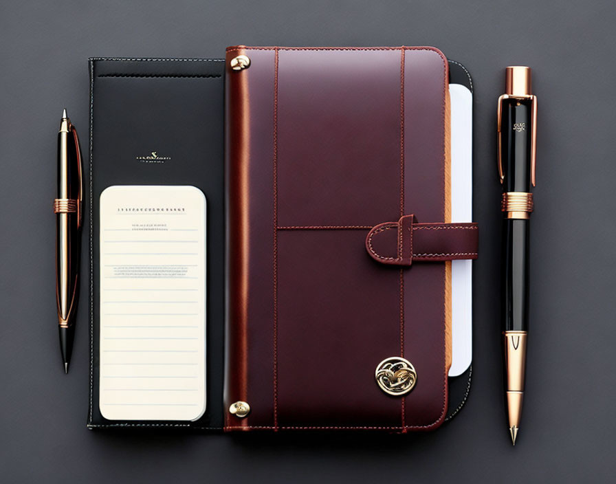 Burgundy Leather Planner Set with Pen and Notepad on Dark Background
