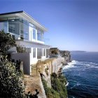 Stylish couple on balcony overlooking blue sea and coastal building