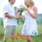 Elderly Couple in Light Blue and White Outfits Holding Roses