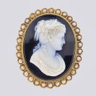 Intricately crafted cameo brooch with woman profile and floral design on gold oval base