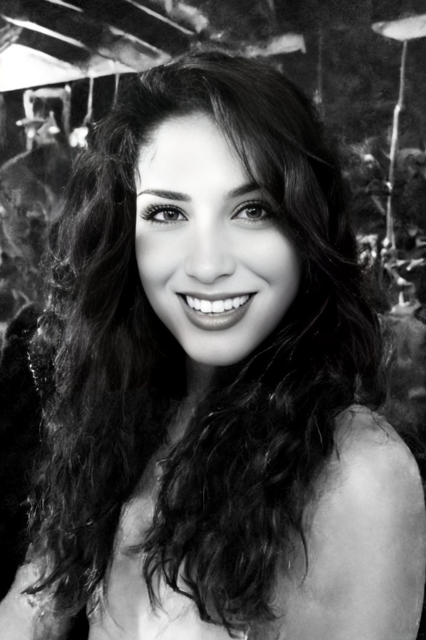 Monochrome portrait of smiling woman with curly hair in lively setting