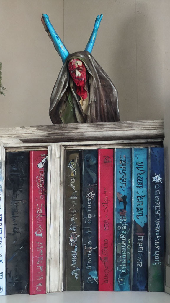 Blue-horned figurine on colorful books shelf