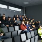 Audience with varied expressions and dogs in grey-toned auditorium