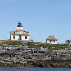 Tranquil coastal scene with lighthouse on cliff and flying birds