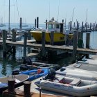 Colorful boats on calm blue water with figure by dock