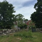 Vibrant countryside scene: stone house, colorful trees, blue sky