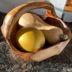 Wooden bowl with patterned gourds and spoon on geometric backdrop