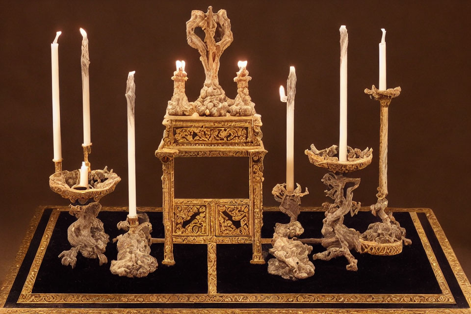 Golden mirror with candles on stands on black surface