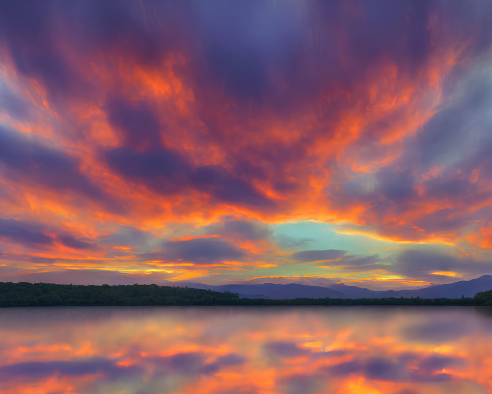 Scenic sunset with fiery clouds reflected on tranquil lake