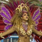 Intricate golden headdress and radiant feather collar in purple, gold, and blue hues