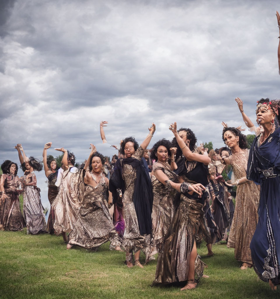 Group of people dancing outdoors in expressive poses on grassy field under cloudy sky