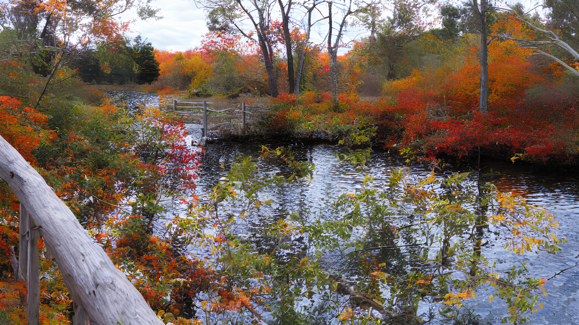 Tranquil pond with vibrant autumn trees and wooden bridge