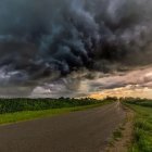 Intense thunderstorm with lightning strikes over highway car.