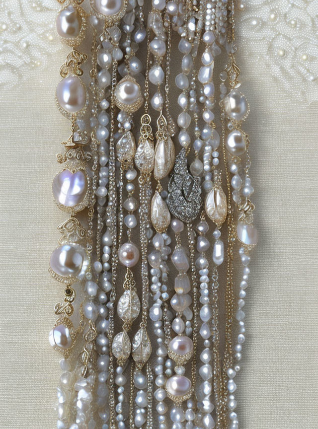 Pearl Necklaces with Gold Elements and Diamond Accents on Beige Fabric