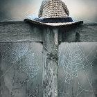 Straw hat on wooden post with blue and white flora and soft-focus background